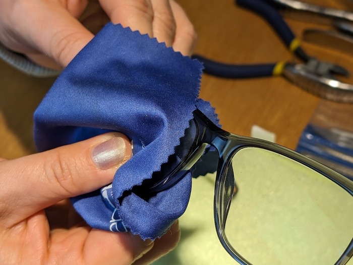 Optiker reparerar en glasögonbåge